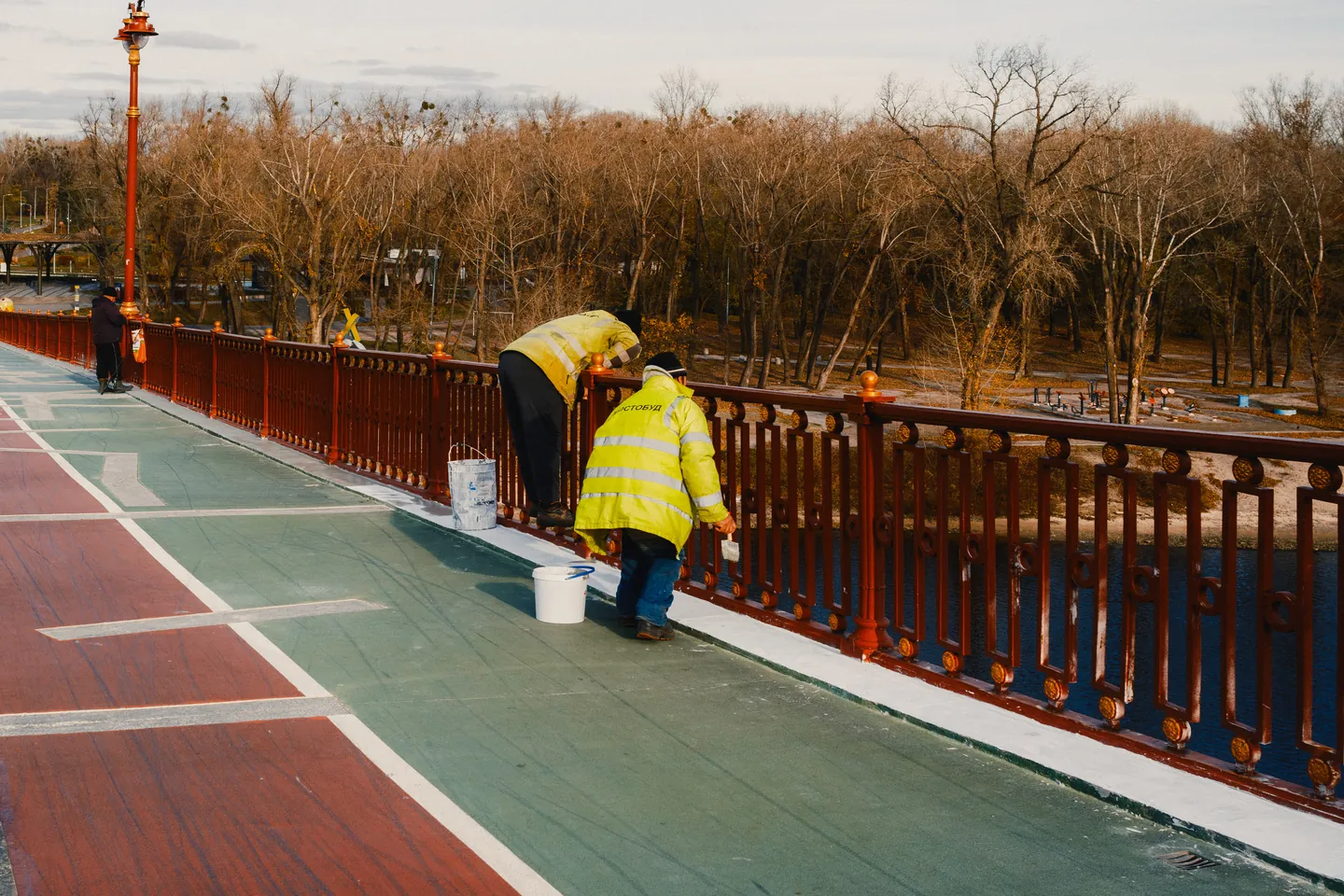 Workers repaint the bridge’s red railings.