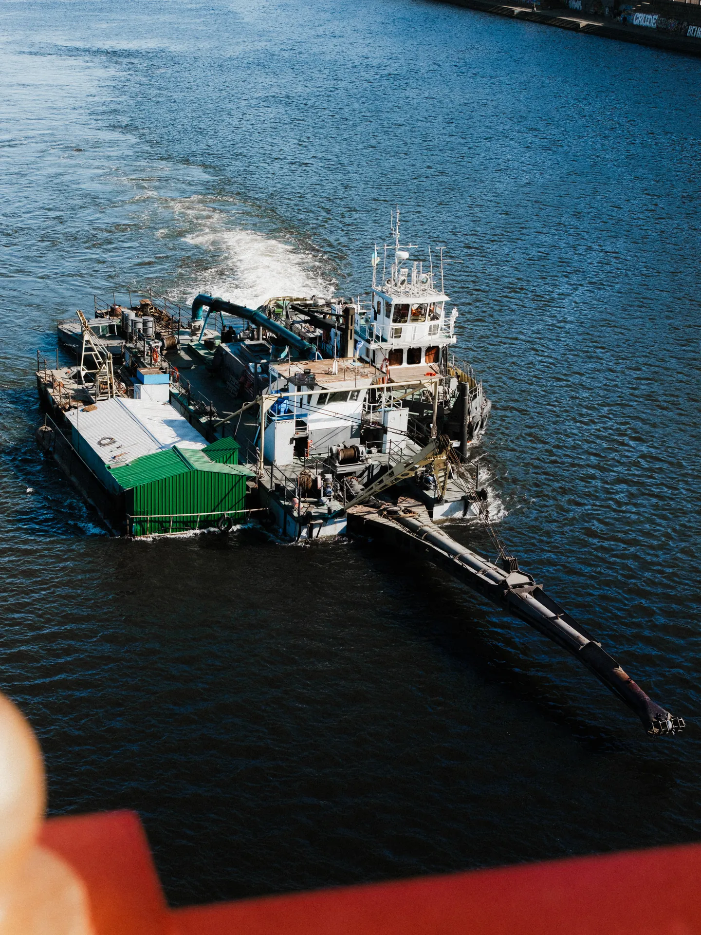 A working vessel on the river, seen from above.