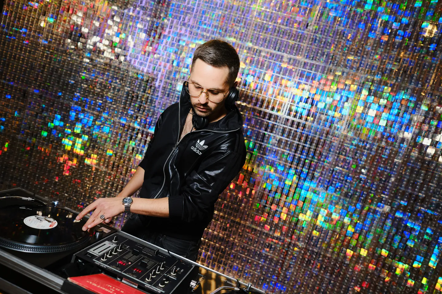 DJ against a reflective mosaic wall