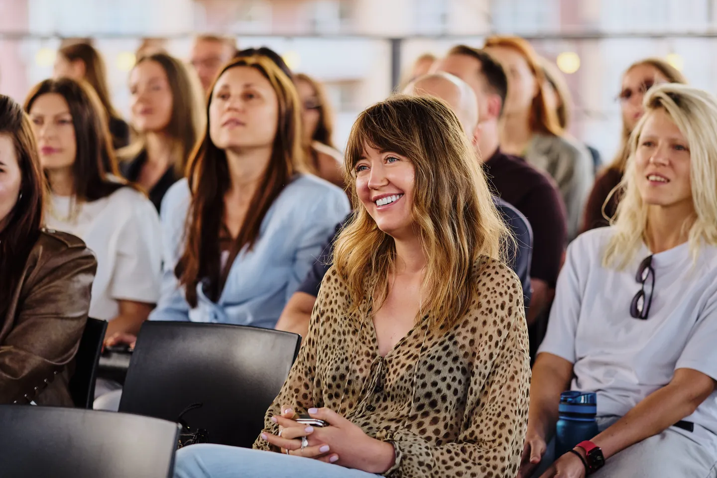Smiling audience at a talk